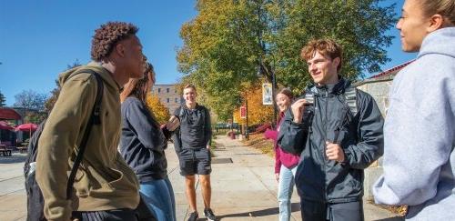 Five students talking outside on the quad